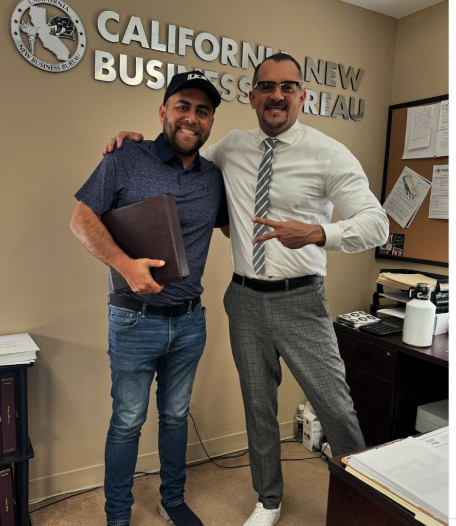 Christian Vasquez with a client receiving their corporate kit